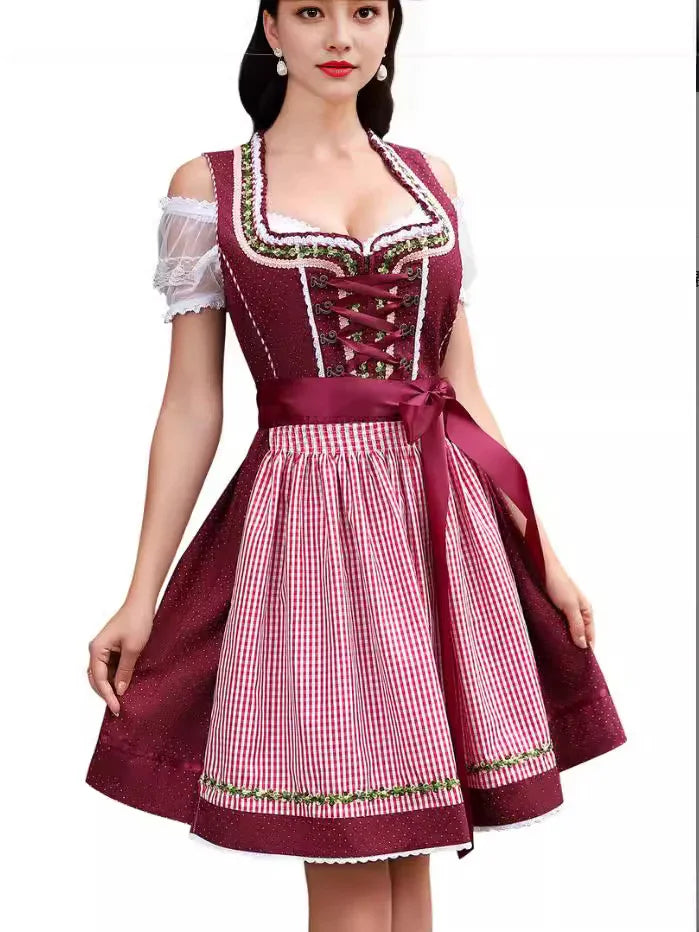 Woman in traditional maroon dirndl dress with lace-up bodice and red gingham apron