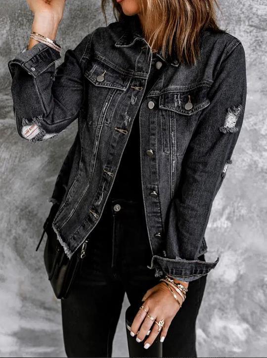Woman wearing distressed black denim jacket with rolled sleeves and black jeans, accessorized with bracelets and rings