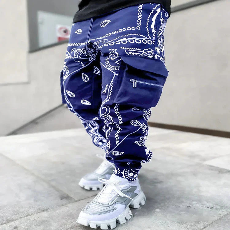 Close-up of blue paisley print cargo pants with zipper pocket, worn with white chunky sneakers