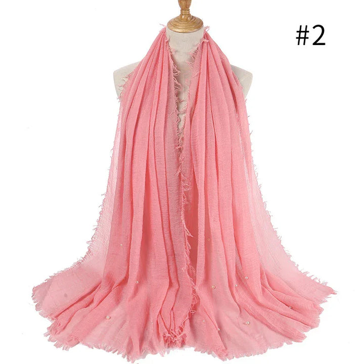 Soft pink fringed scarf with subtle pearl embellishments displayed on mannequin