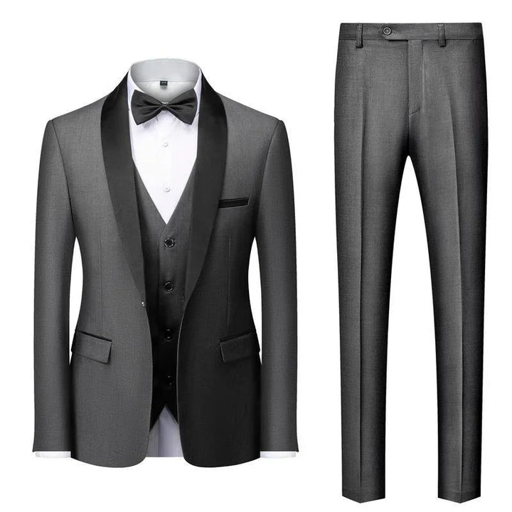 Elegant gray men's tuxedo with black satin shawl lapel, white shirt, black bow tie, vest, and matching pants