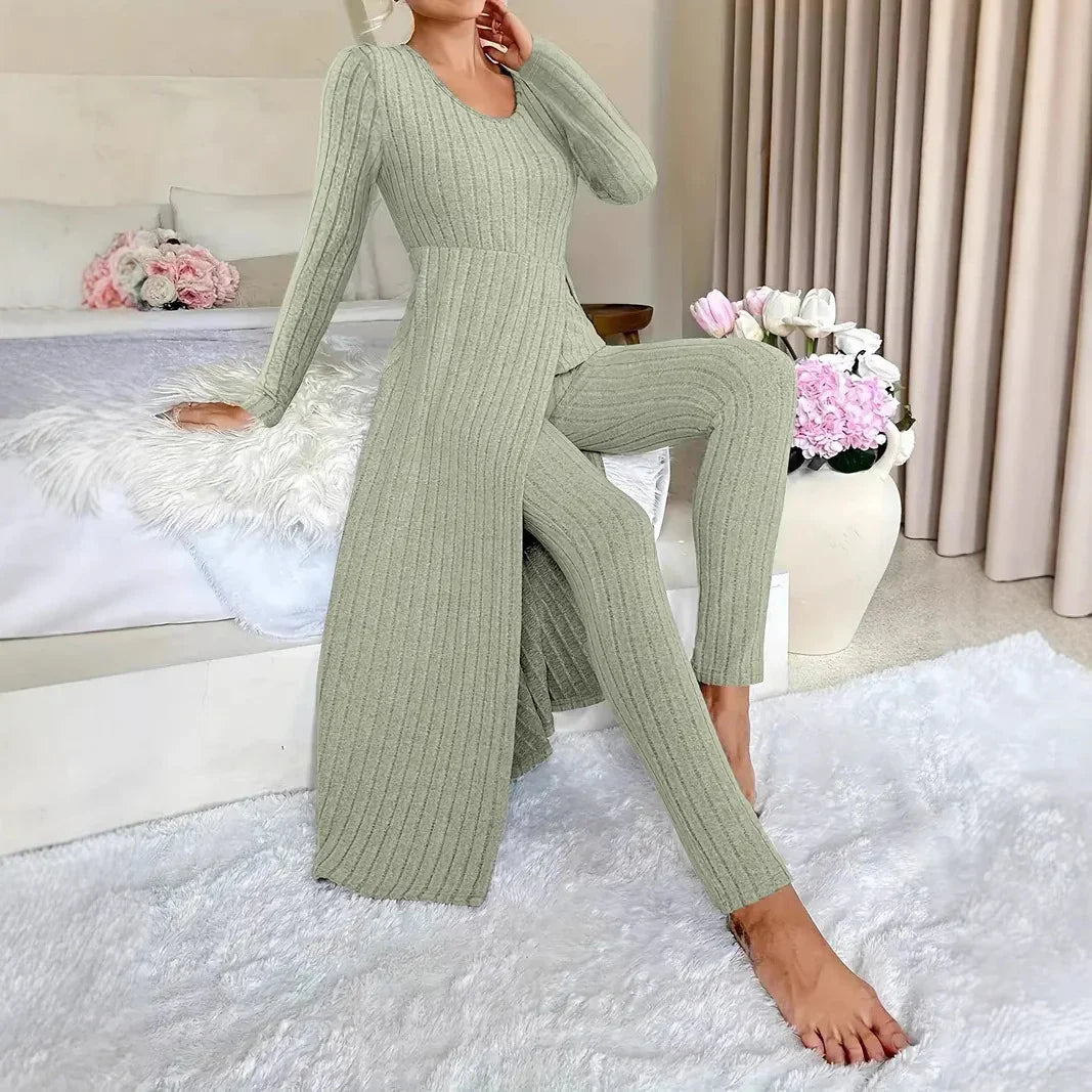 Woman wearing sage green ribbed knit long top and matching pants in cozy modern bedroom with floral decor