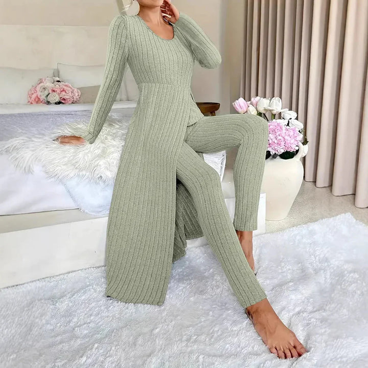 Woman wearing sage green ribbed knit long top and matching pants in cozy modern bedroom with floral decor