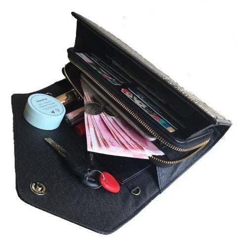 Black leather wallet open with cash, coins, credit cards, keys, and lip gloss inside