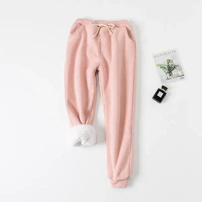Soft pink fleece-lined sweatpants with drawstring waist and pockets on white background
