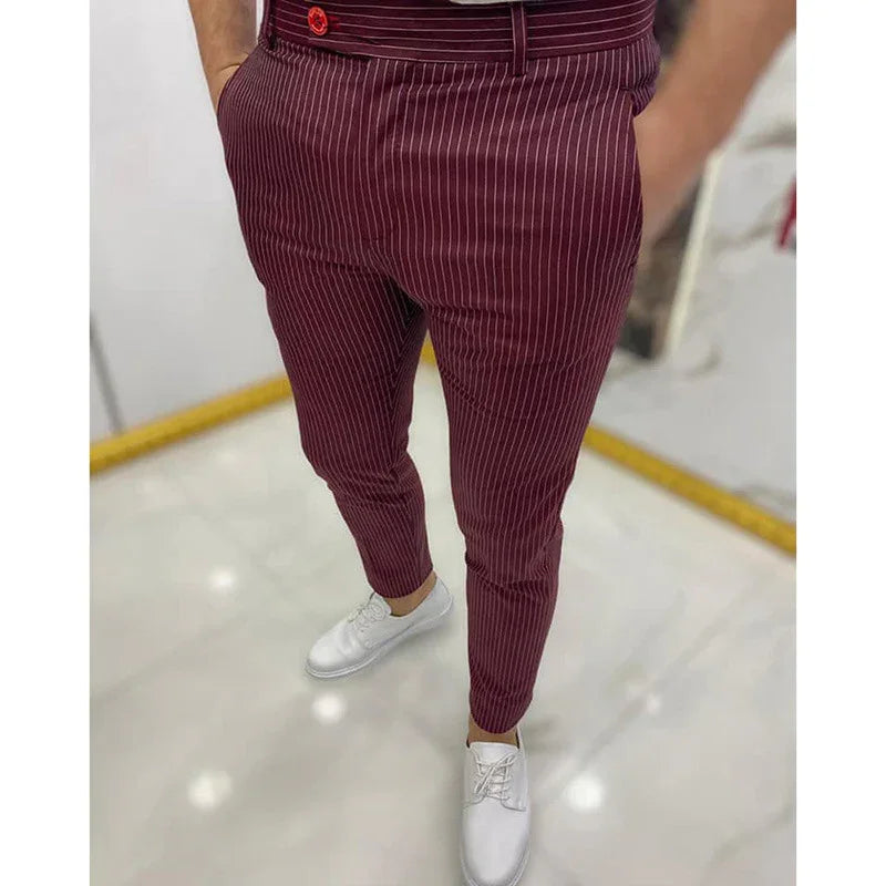 Man wearing maroon pinstripe slim-fit trousers and white sneakers on marble floor