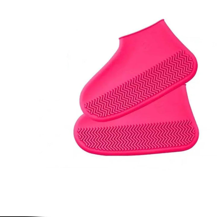Pair of bright pink silicone shoe covers with textured soles on white background