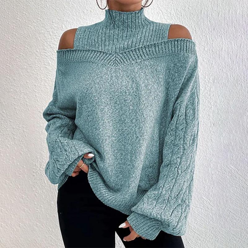 Woman wearing blue-green cold shoulder knitted sweater with high collar and puffed sleeves