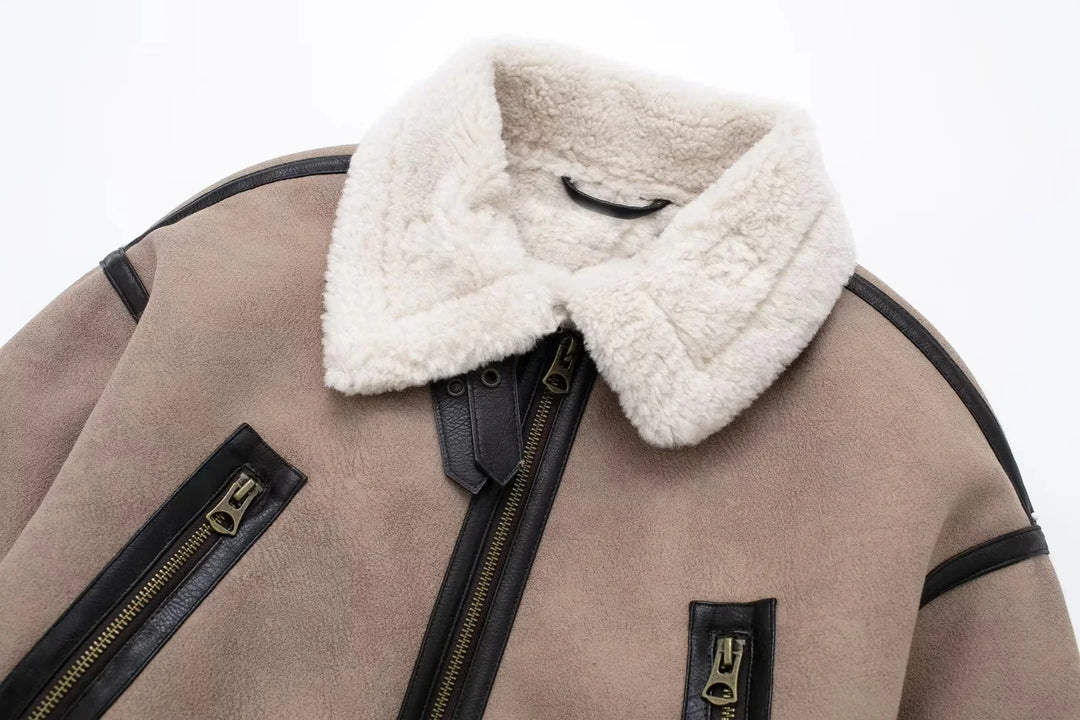 Beige shearling aviator jacket with white fluffy collar and black leather trim zipper details