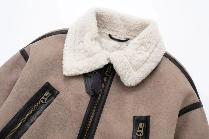 Beige shearling aviator jacket with white fluffy collar and black leather trim zipper details