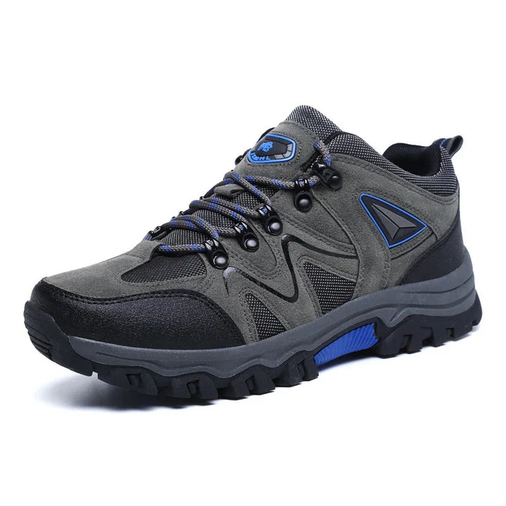 Gray and black hiking shoe with blue accents and rugged sole on white background