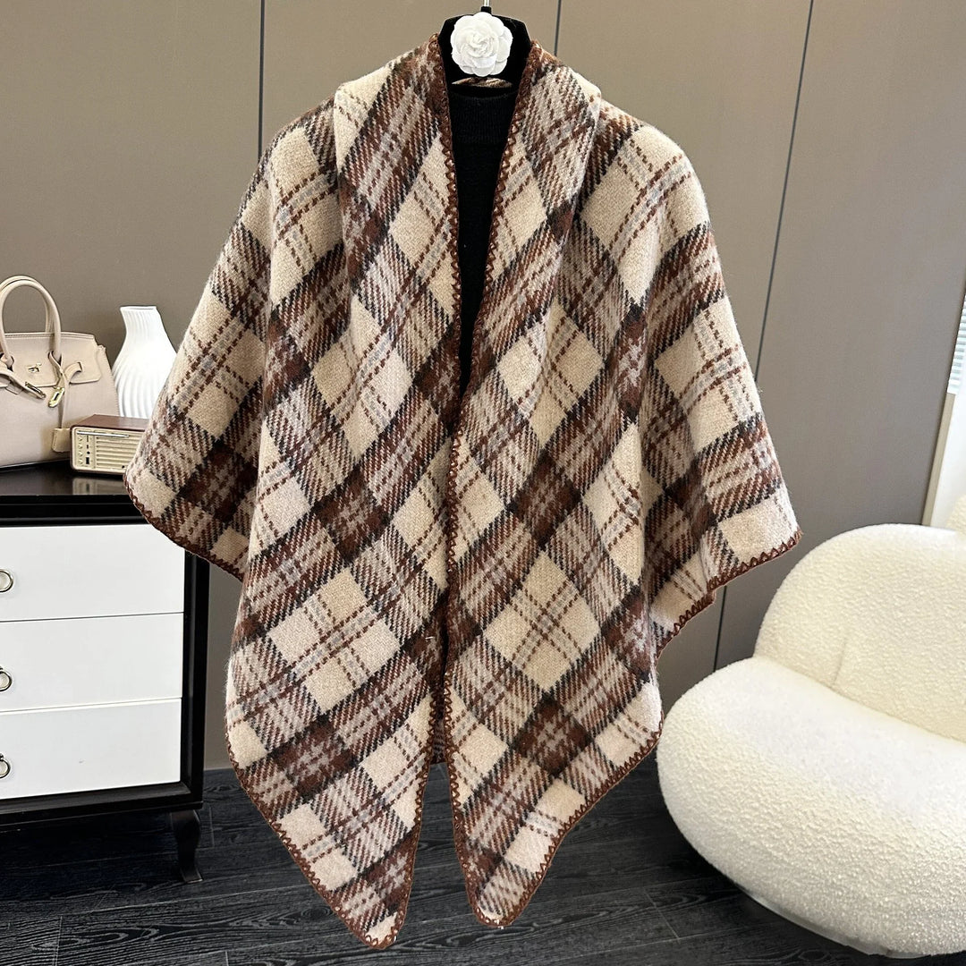 Brown and beige plaid wool poncho displayed on black mannequin in modern room