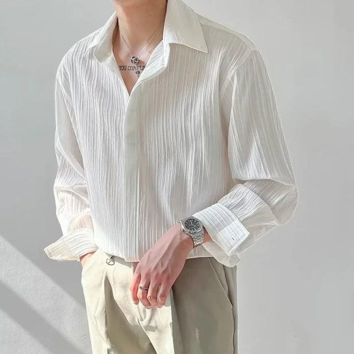 Man wearing white textured long-sleeve shirt paired with beige pants and silver watch