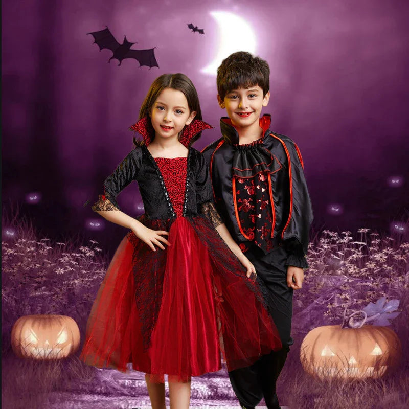 Two children in vampire costumes with red and black details standing in a spooky Halloween scene with jack-o'-lanterns and bats