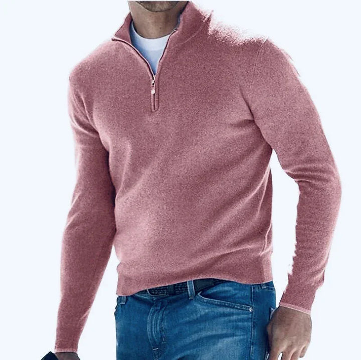 Man wearing pink quarter-zip sweater and blue jeans, casual fashion style