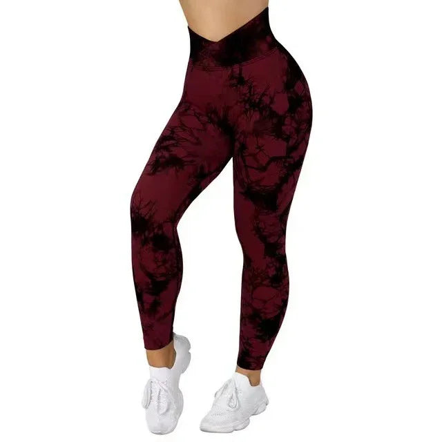 Woman wearing high-waisted burgundy and black tie-dye leggings with white sneakers