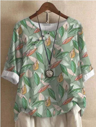 Light green leaf print blouse with rolled sleeves paired with white pants and pendant necklace