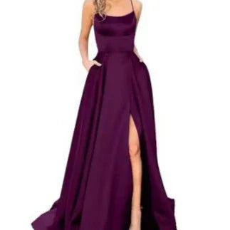 Woman wearing floor-length sleeveless dark purple evening gown with thigh-high slit and pockets