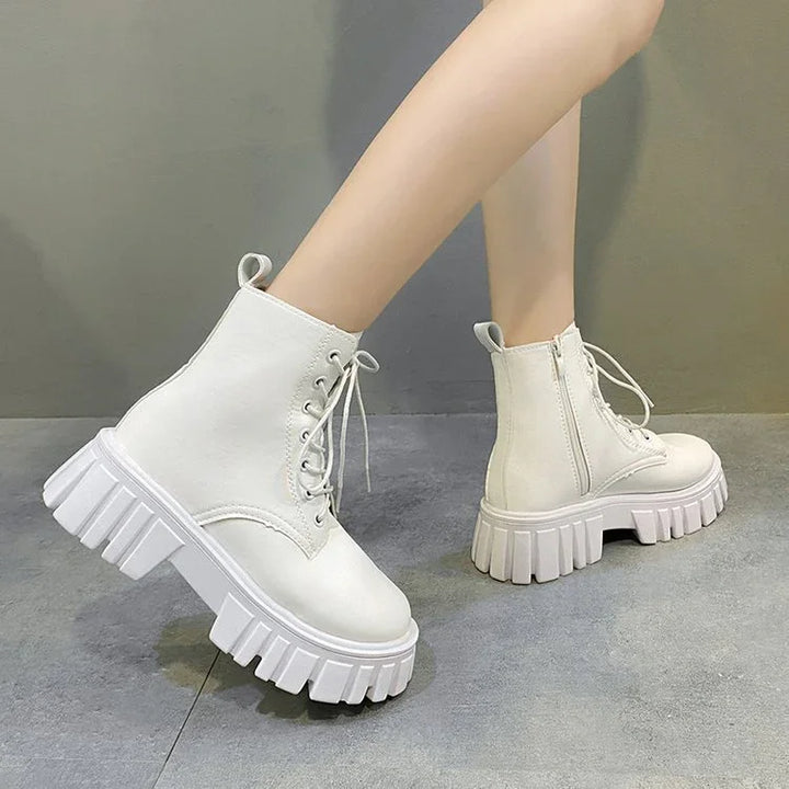 White chunky platform lace-up ankle boots with side zipper on gray floor