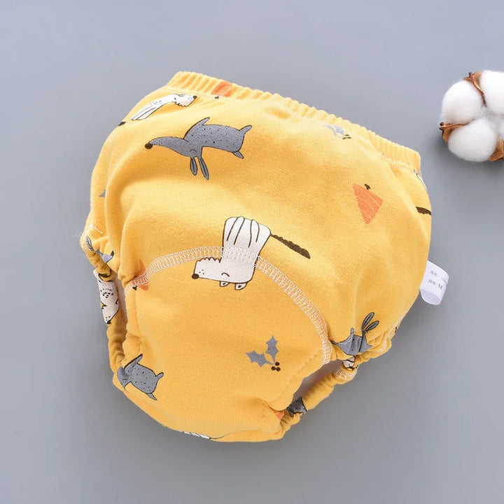 Yellow baby cloth diaper with animal and plant prints on grey background