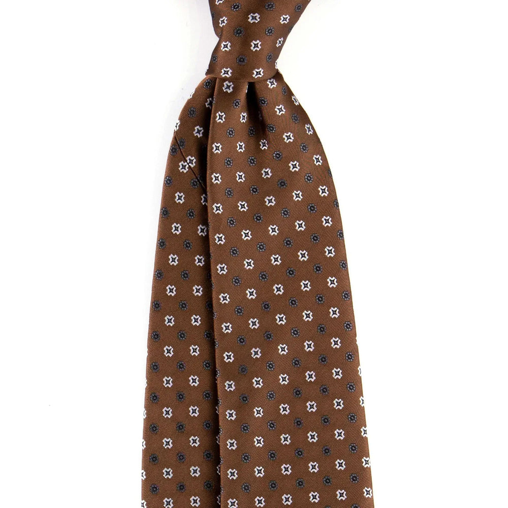 Brown silk necktie with small white and black floral pattern on white background