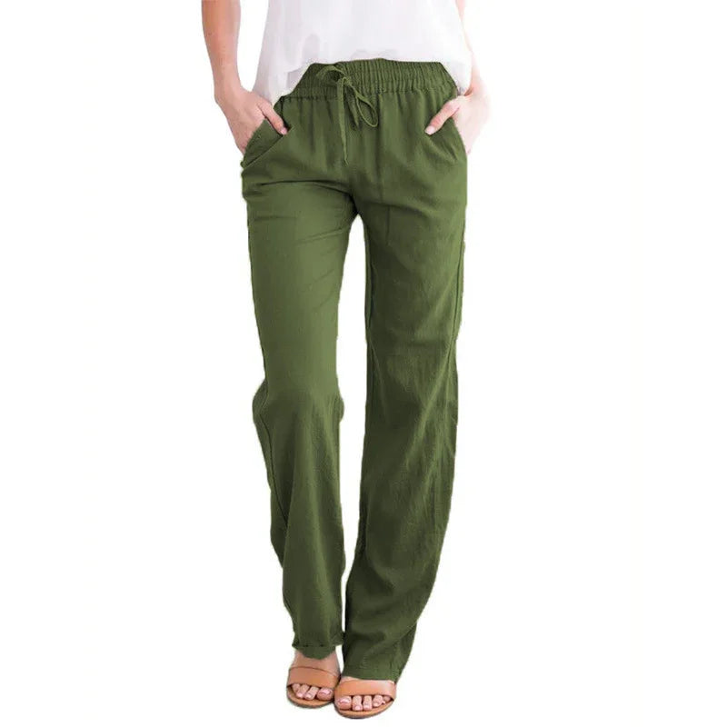Woman wearing olive green relaxed fit drawstring pants with pockets and brown sandals