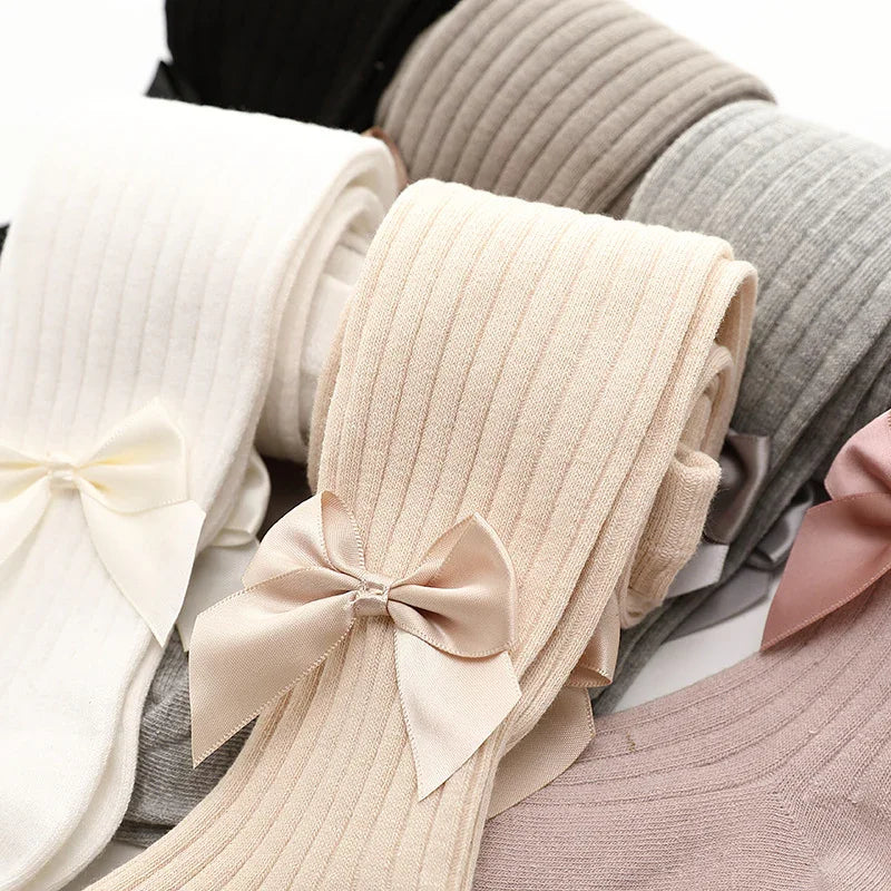 Ribbed knit tights in beige, white, gray, and pink with satin bows on each pair