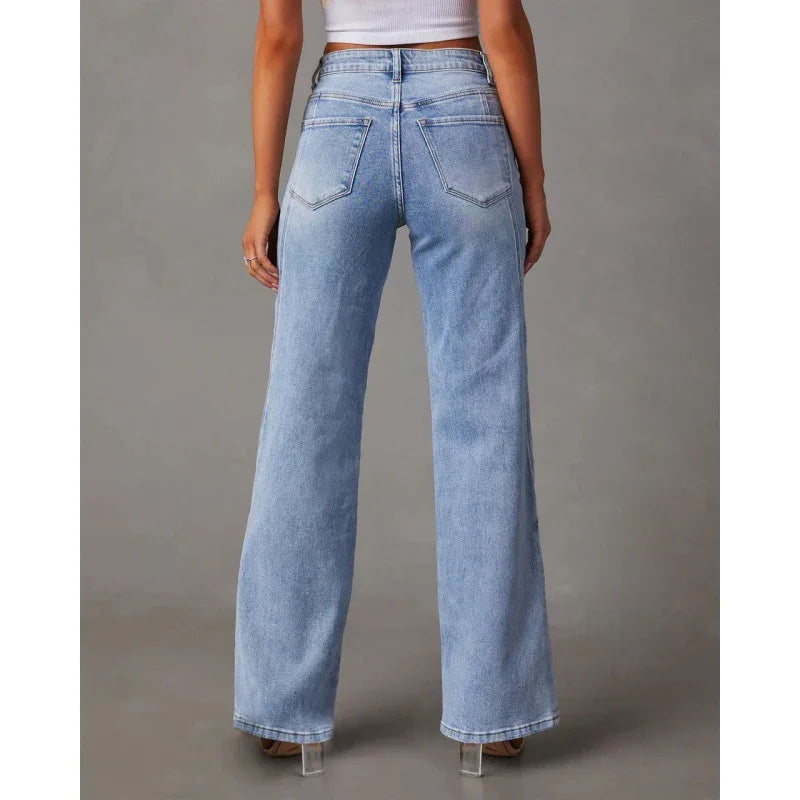 Back view of woman wearing light blue high-waisted wide-leg jeans and white crop top