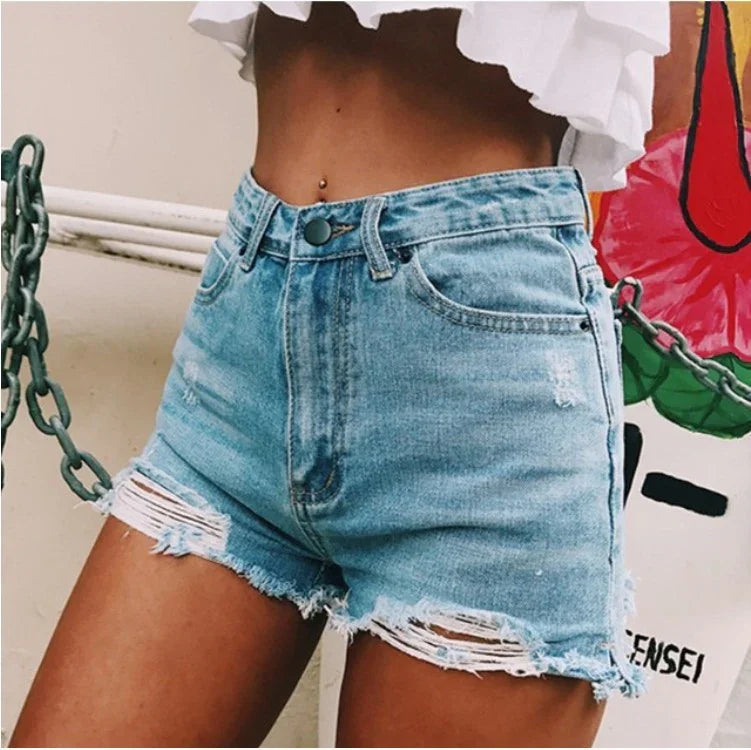 High-waisted light blue distressed denim shorts with frayed hems worn with a white cropped top