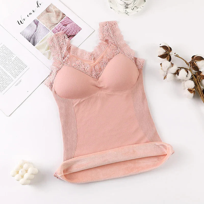 Pink lace-trimmed seamless padded camisole on white surface with cotton branch and magazine