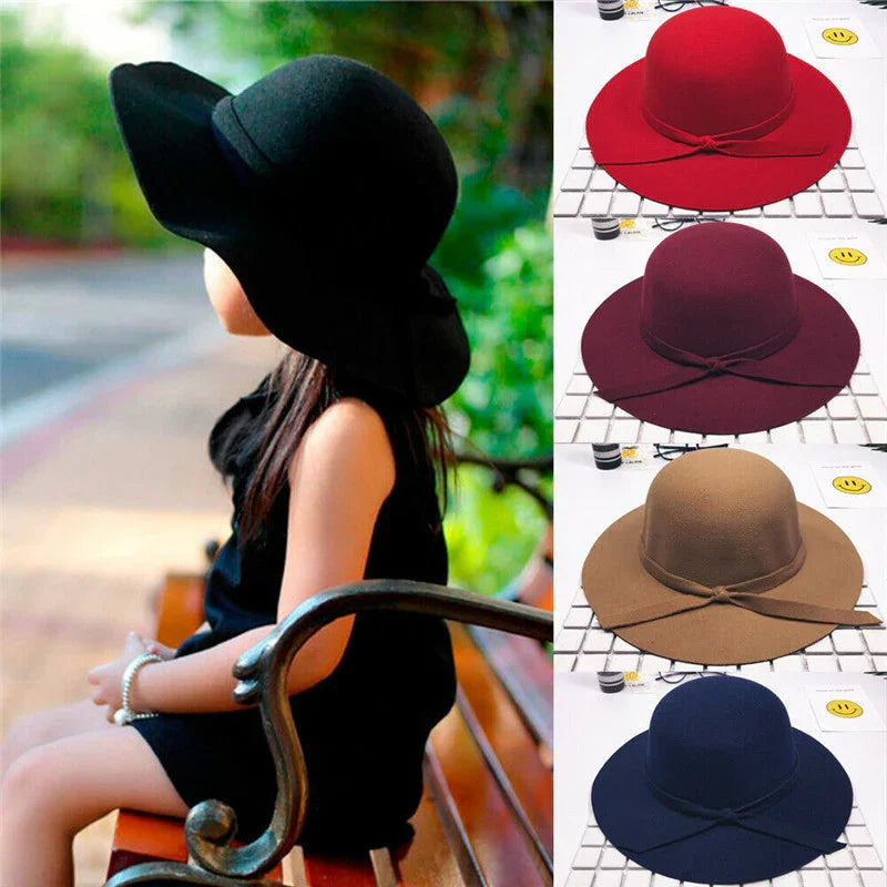 Girl wearing black wide-brimmed hat sitting on wooden park bench with four color options of similar hats