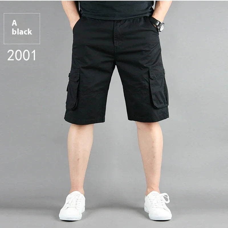 Man wearing black cargo shorts with pockets and white sneakers on gray background