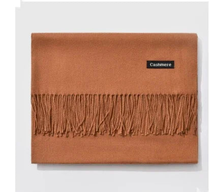 Folded brown cashmere scarf with fringed edges and black label on white background