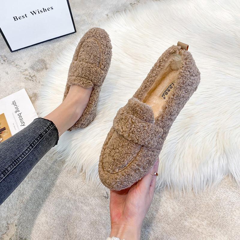 Soft brown fuzzy slippers on white rug, cozy warm indoor footwear with plush texture