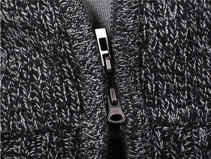 Close-up of black and white knitted fabric with a silver zipper in the center