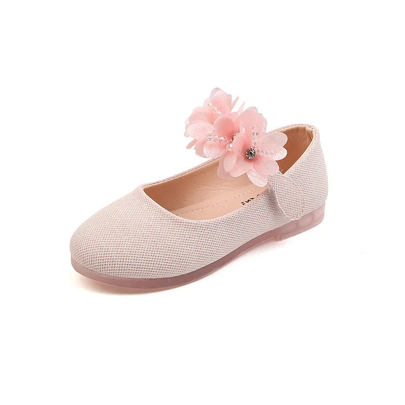 Light pink girls' flat shoe with textured fabric and decorative floral embellishment
