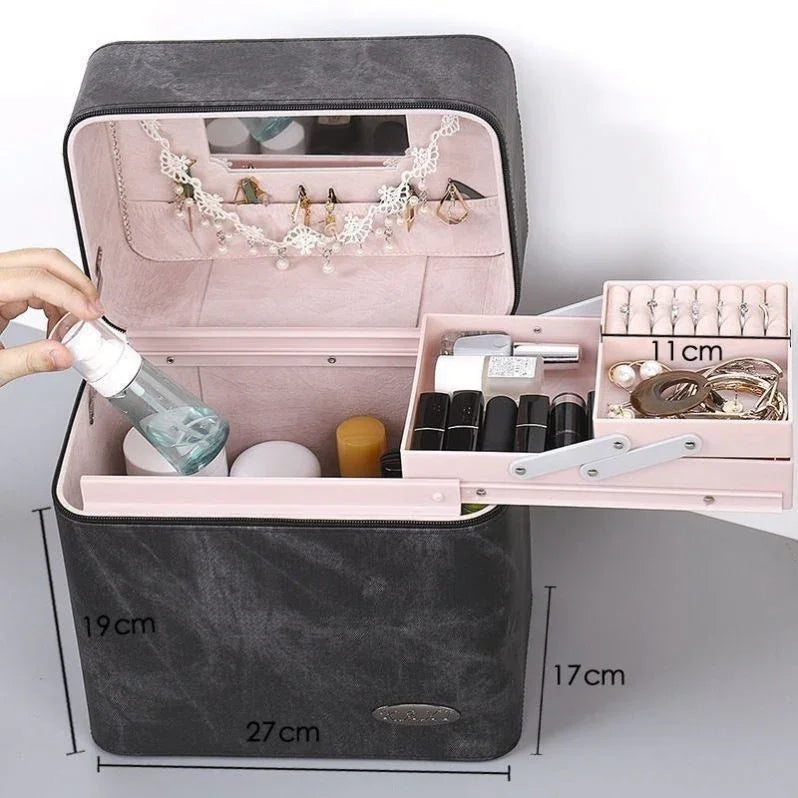 Black and pink jewelry organizer box open showing rings, earrings, lipsticks, and skincare bottles inside