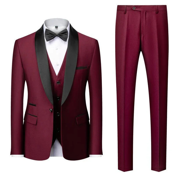 Men's burgundy tuxedo suit with black satin lapels, matching vest, white shirt, black bow tie, and pants