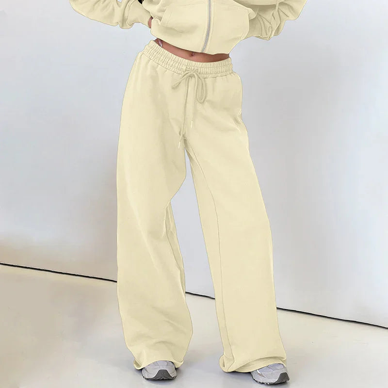 Woman wearing beige wide-leg sweatpants with drawstring waist and white sneakers