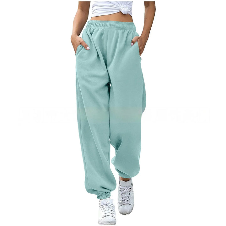 Woman wearing light blue loose sweatpants with elastic cuffs and white sneakers