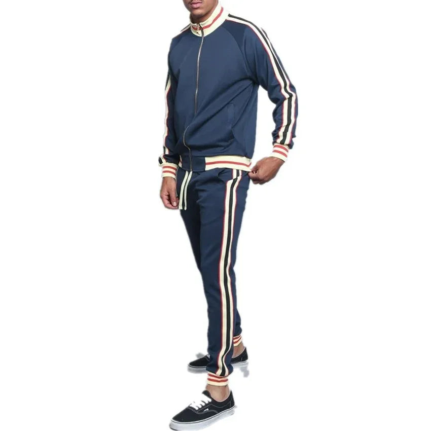 Man in navy blue tracksuit with red and white stripes, wearing black sneakers