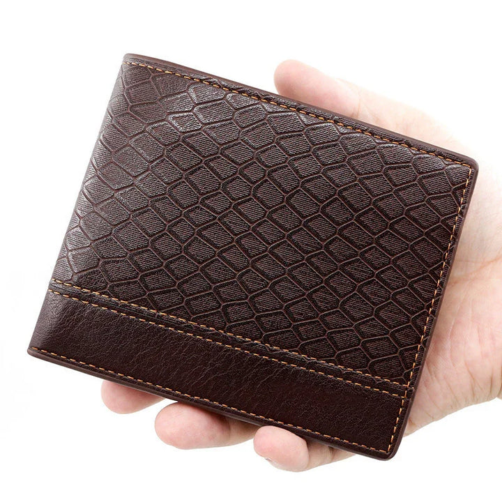 Hand holding a brown leather wallet with textured pattern and orange stitching