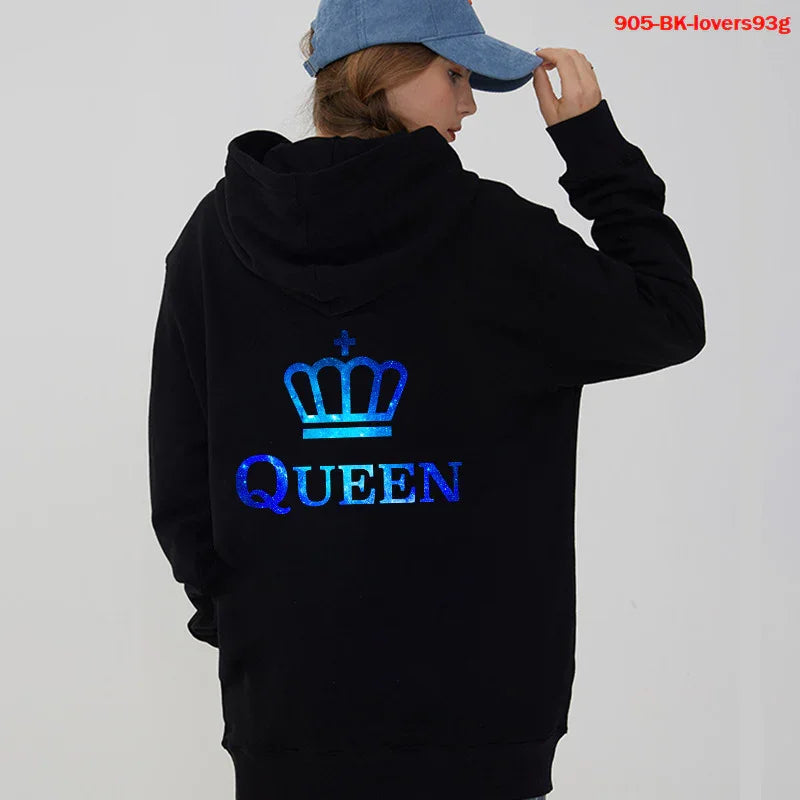 Woman wearing black hoodie with blue crown and Queen text on back, paired with blue cap