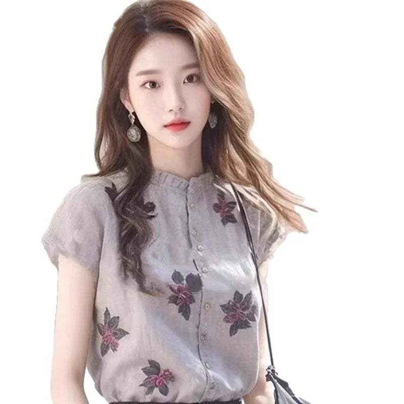 Young woman with long wavy hair wearing floral button-up blouse and statement earrings