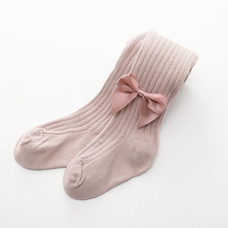 Pair of soft pink ribbed knit socks with a satin bow detail on a white background