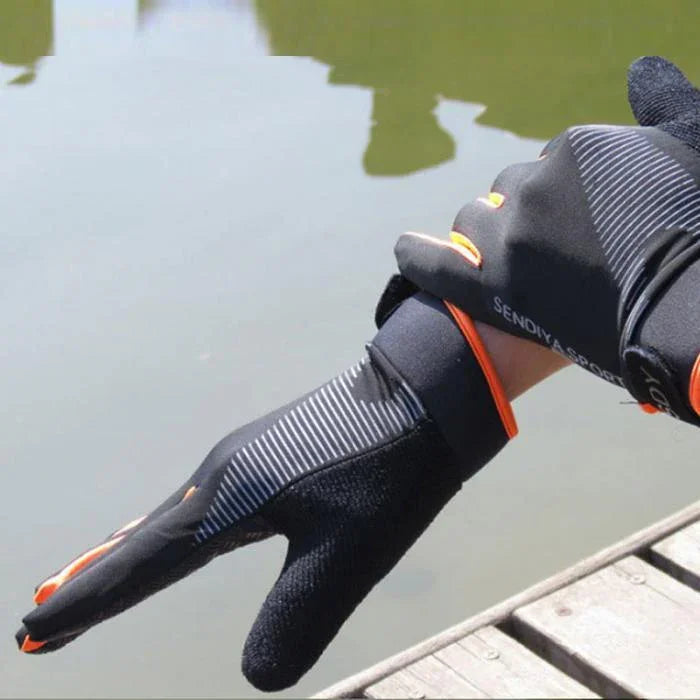 Person wearing black and orange Sendix waterproof gloves near water by a wooden dock