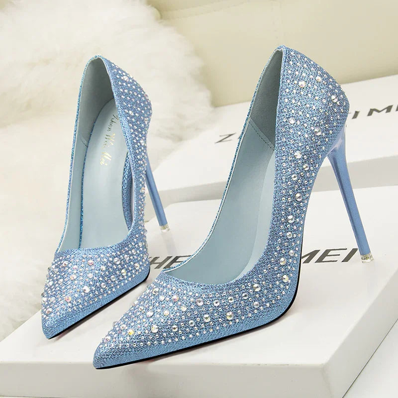 Elegant blue high heels with sparkling rhinestone embellishments on a white box