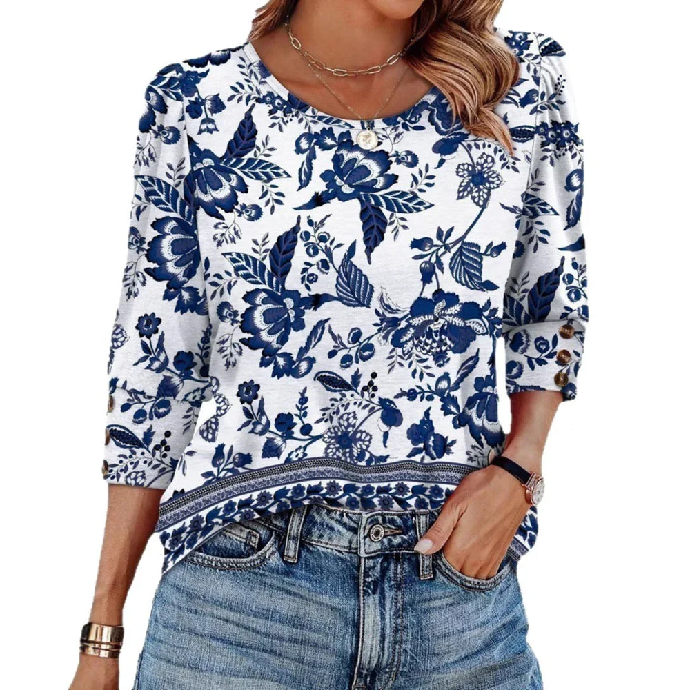 Woman wearing white blouse with blue floral print and 3/4 sleeves paired with blue jeans