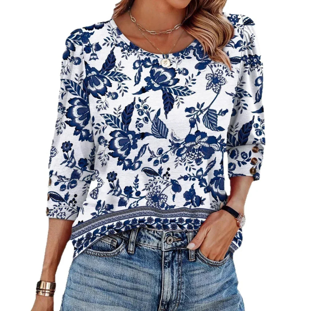 Woman wearing white blouse with blue floral print and 3/4 sleeves paired with blue jeans