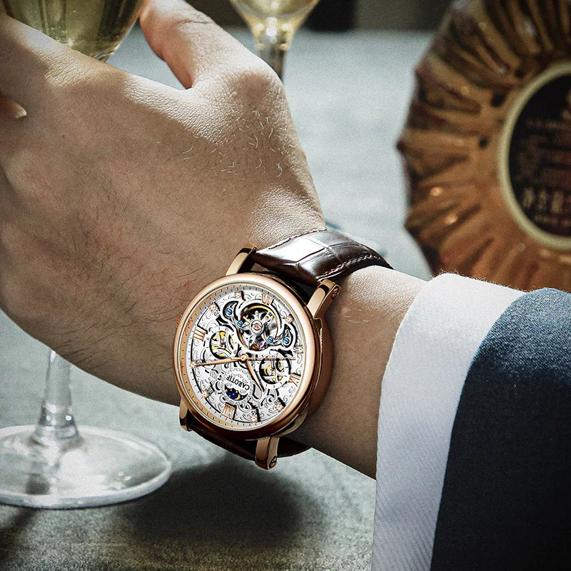 Luxury skeleton watch with brown leather strap on wrist, holding a glass of champagne
